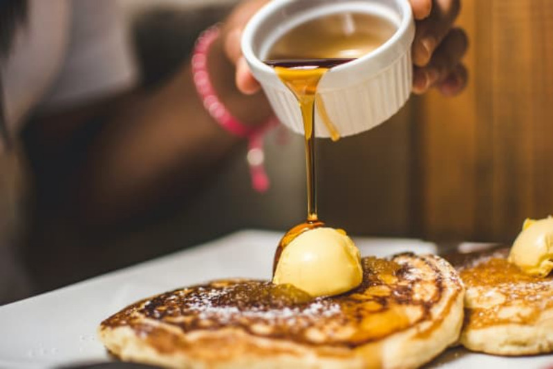 Pouring syrup on a pancake